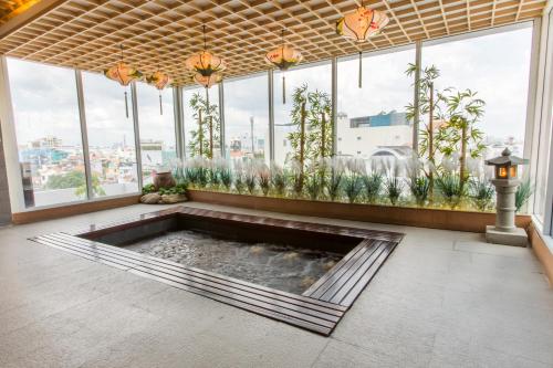 a large room with a pond in the middle of a building with windows at Minh Tam Hotel and Spa in Ho Chi Minh City