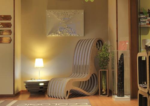 un banco de madera en una sala de estar con lámpara en eco Hotel Milano & BioRiso Restaurant en Milán