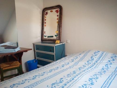 - une chambre avec un lit et un miroir sur une commode dans l'établissement Au calme, à Houssay
