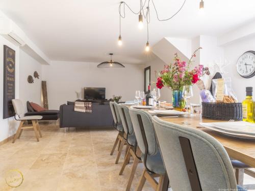 a dining room and living room with a table and chairs at Les Garrigues de la Vallée des Baux in Paradou
