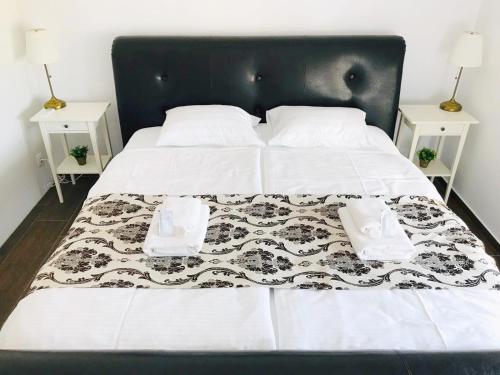 a black and white bed with two night stands at Villa Residence in Sînmartin