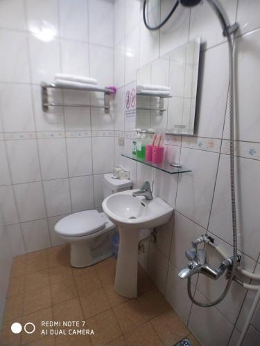 a bathroom with a sink and a toilet and a mirror at 玖拾捌民宿-98bnb in Hualien City