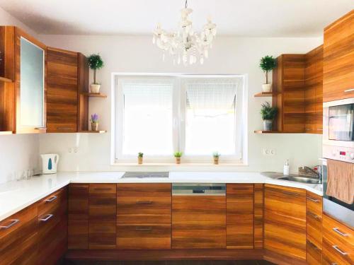 a kitchen with wooden cabinets and a chandelier at Villa Residence in Sînmartin