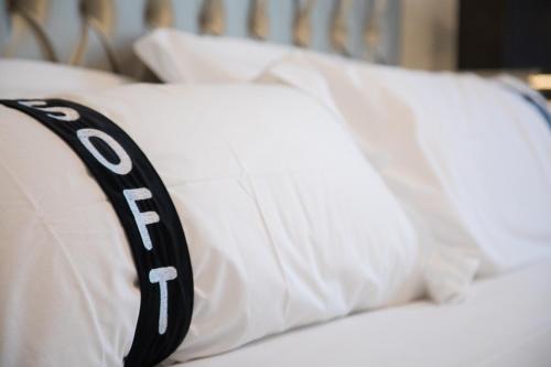 a bed with white pillows with the wordoit at Casual Belle Epoque Lisboa in Lisbon
