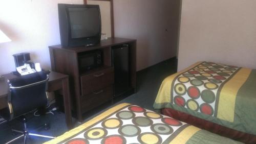 a hotel room with two beds and a desk and a television at Quality Inn in West Haven