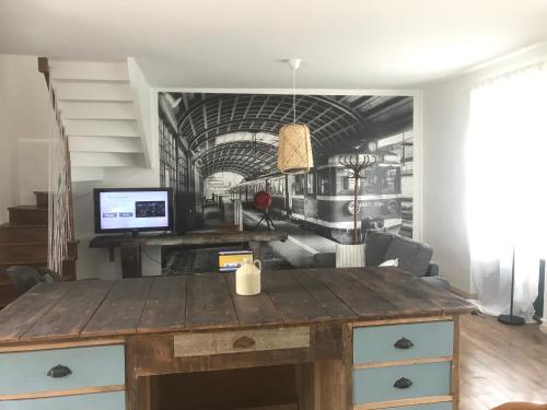 una scrivania di legno in un soggiorno con un murale raffigurante un treno di Cottage familial a Ozeville