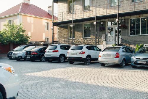 a row of cars parked in front of a building at Korona Hotel in Boryspilʼ