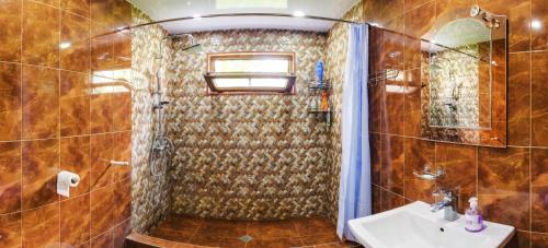 ein Bad mit einer Dusche und einem Waschbecken in der Unterkunft Guest House Mart Villa in Martvili