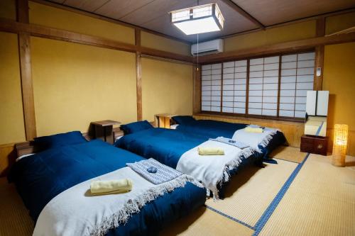 Habitación con 3 camas azules en una habitación en Toemu Nozawa Lodge, en Nozawa Onsen