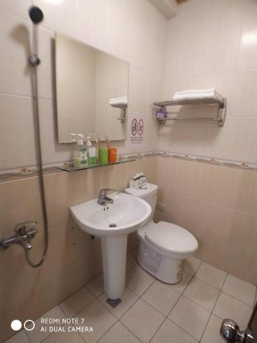 a bathroom with a toilet and a sink and a mirror at 玖拾捌民宿-98bnb in Hualien City