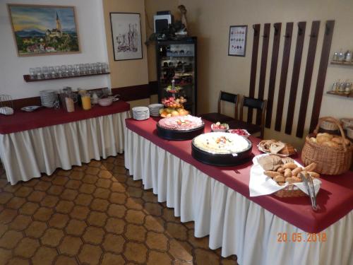 einen Tisch mit weißen Tischen und Essen drauf in der Unterkunft Parkhotel Zuzek in Sankt Kanzian am Klopeiner See