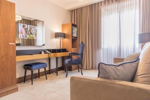a hotel room with a desk and a couch at Casual Belle Epoque Lisboa in Lisbon