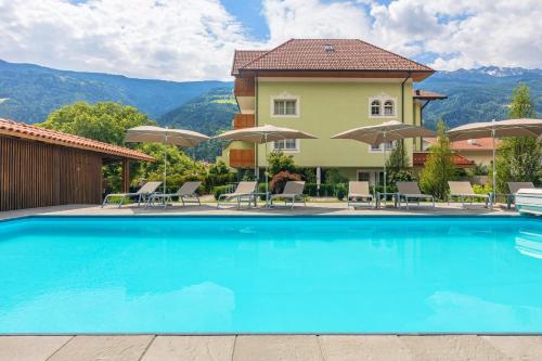 a pool at a hotel with chairs and umbrellas at Wohlfühlhotel Mei Auszeit in Plaus