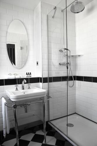 a bathroom with a sink and a shower at Hôtel Léna in Paris
