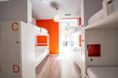a room with two bunk beds and an orange wall at Safestay Madrid Central in Madrid
