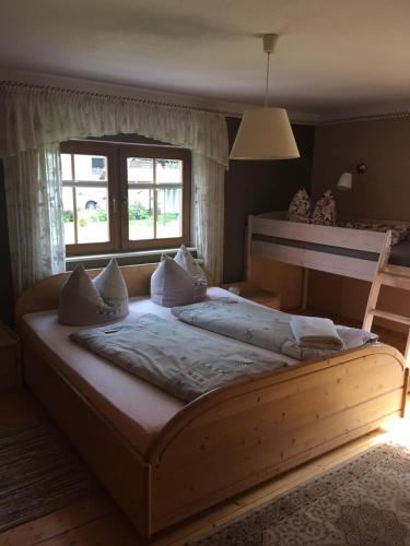 a large wooden bed in a bedroom with a window at Ferienwohnung Schulze Jonsdorf in Kurort Jonsdorf