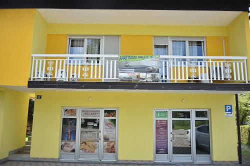 a yellow building with a balcony on top of it at Apartman Nikolic,Banja Vrucica,Teslic in Teslić