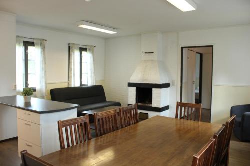 a living room with a table and a fireplace at Visulahti Cottages in Mikkeli