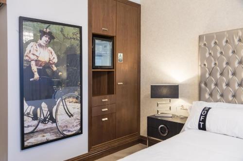 a hotel room with a poster of a woman riding a bike at Casual Belle Epoque Lisboa in Lisbon
