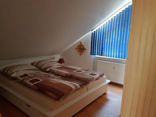 Bett in einem Zimmer mit Fenster in der Unterkunft Stürmlesloch in Bad Wildbad