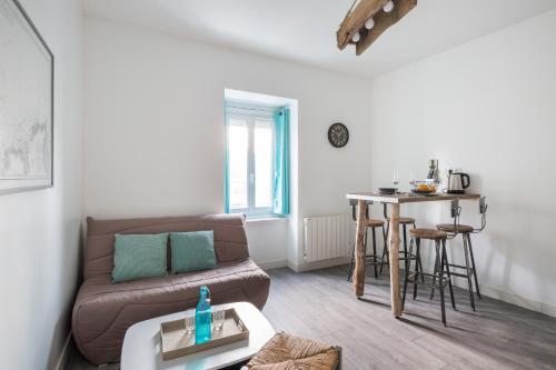 ein Wohnzimmer mit einem Sofa und einem Tisch in der Unterkunft Appartement Cosy 4P - L'Ar Zenith in Saint-Malo