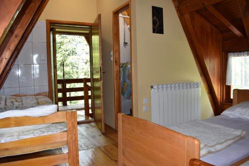Vikendica Balvaniste في ياهورينا: غرفة نوم بسريرين وباب مفتوح