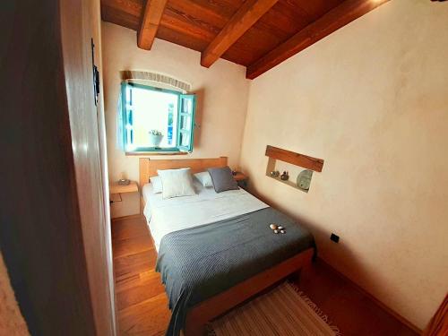 a small bedroom with a bed and a window at Apartment Nona Keka in Cres