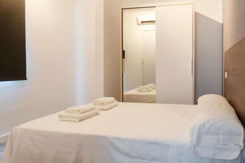 a bedroom with a white bed with a mirror at Mallorca Rooms Can Pastilla in Can Pastilla