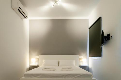 Mallorca Rooms Can Pastilla في كان باستيليا: غرفة نوم بسرير ابيض عليها منشفتين