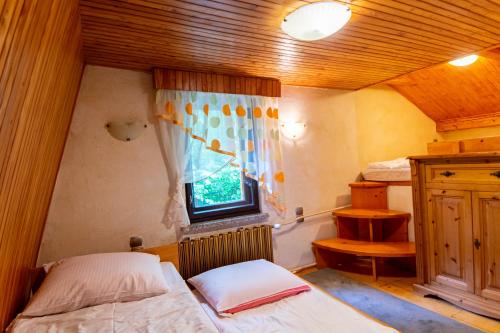 een kleine kamer met een bed en een raam bij Domek Brenna in Brenna