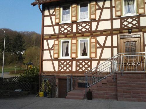 a house with a staircase in front of it at Kreuzdellenhof Ferienzimmer in Hembach