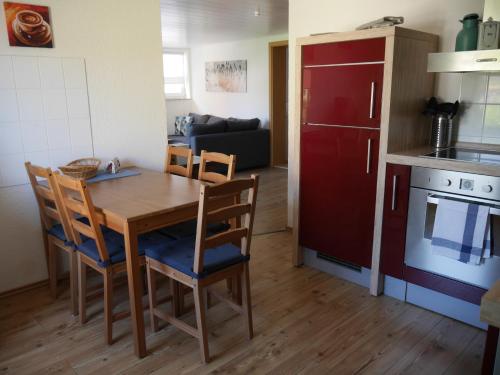 a kitchen and dining room with a wooden table and chairs at Alte Schmiede Sagard in Sagard