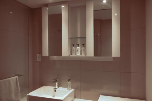 La salle de bains est pourvue d'un lavabo et d'un miroir. dans l'établissement iTowers Studio Suite, à Gaborone