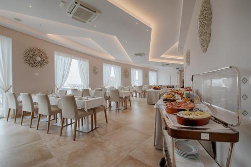 a large dining room with tables and chairs with food at Roma Hotel in Castiglione della Pescaia