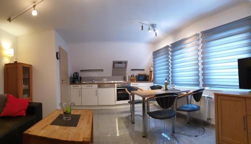 een woonkamer met een tafel en een keuken bij Haus Bramland --- 2 FeWo's --- EG 60qm und OG 55qm in Haselünne