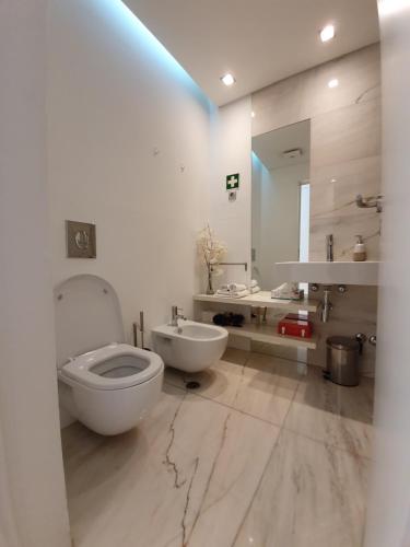 uma casa de banho com um WC, um lavatório e um espelho. em Sophia em Ponta Delgada