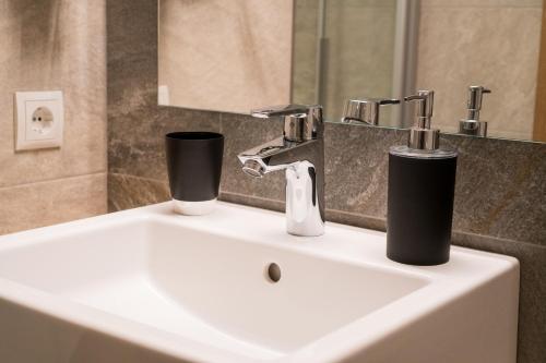 a bathroom sink with two cups on top of it at Innertrein in Cadipietra
