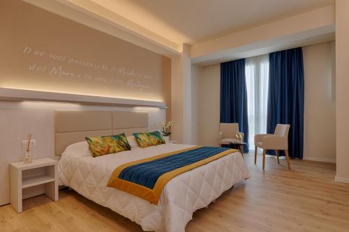 a bedroom with a large bed with a painting on the wall at Roma Hotel in Castiglione della Pescaia