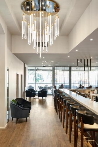 un restaurante con un bar con sillas negras y una lámpara de araña en Quality Hotel Wangaratta Gateway, en Wangaratta