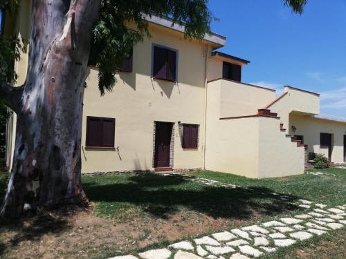 a house with a tree in front of it at Agriturismo Le Folaghe in Terracina