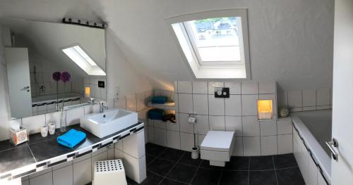 a bathroom with a sink and a toilet and a window at Ferienwohnung Cella in Zell an der Mosel