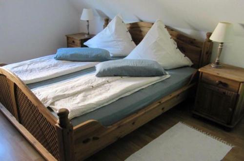 uma cama de madeira com almofadas num quarto em Weissewolke em Bad Fallingbostel