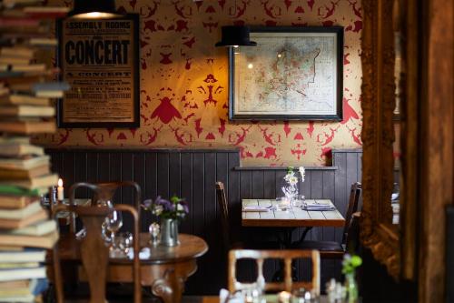a restaurant with a table and chairs and books at The Bell in Ticehurst in Ticehurst