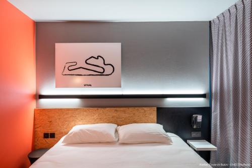 a bedroom with a bed with a sign above it at ibis Styles Bâle-Mulhouse Aéroport in Blotzheim