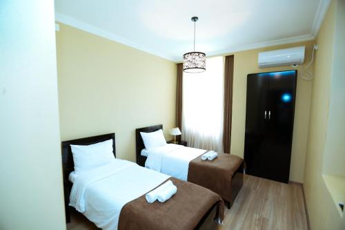 a hotel room with two beds and a chair at Royal Palace Hotel, Lagodekhi in Lagodekhi