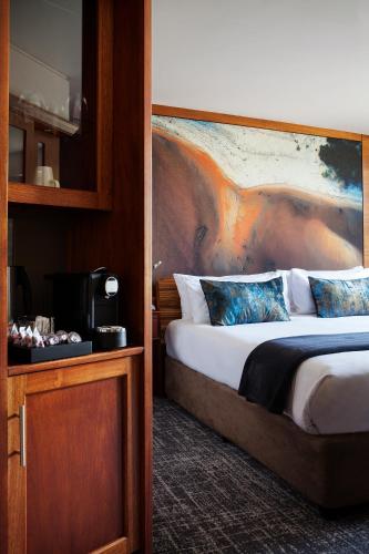 a bedroom with a bed with a painting on the wall at Seven Villa Hotel & Spa in Johannesburg