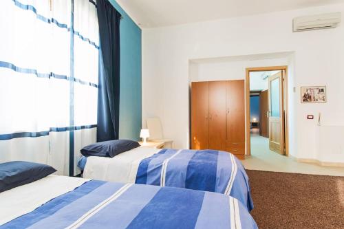 two beds in a room with blue and white at MARY HOUSE in Nuoro