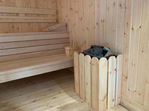 a wooden sauna with a trash can in the corner at Hotel Shpija e Gjyshit in Shkodër