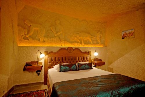 a bedroom with a bed with a wooden head board at Miras Hotel in Göreme