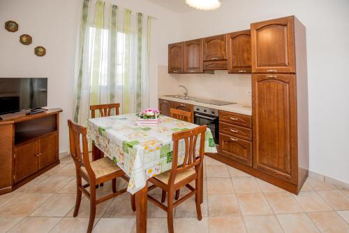 a kitchen with a table and chairs and a kitchen with wooden cabinets at Agriturismo Colle Oliveto in Orbetello